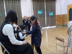 ウサギのペンダントをもらっている子ども