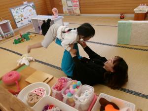 お母さんと飛行機遊びをする子ども
