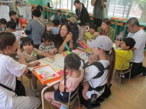4歳児と保護者が笑顔で笹飾りをしている