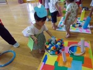 1歳児が輪投げをしています