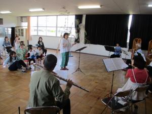 フルート演奏に合わせて、ポンポンを持って踊る子ども