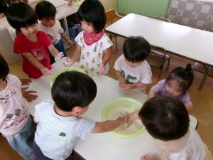 子どもたちが小麦粉の粉をさわっている