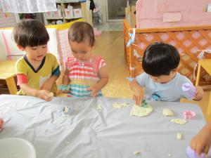 ３人で小麦粉粘土を触っている