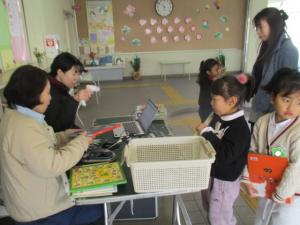 図書館の方に絵本を借りている園児