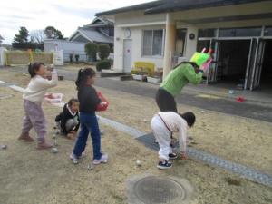 先生に新聞紙の豆を投げる子ども