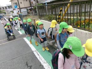 2組とひまわり組が手をつないで歩いています
