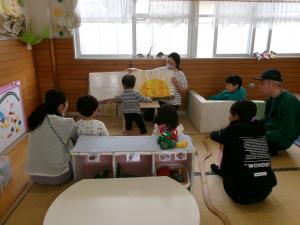 大型絵本を見ている2歳児