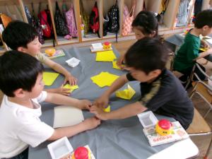 5歳児が折り紙を教えあう様子