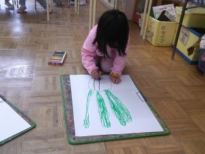たまねぎの絵を描く4歳児の女の子