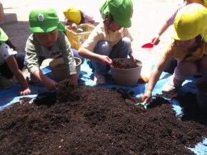 植木鉢に土を入れている子ども達
