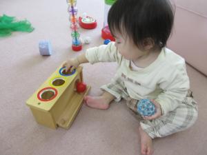 押し込んだボールが転がる玩具で遊んでいるよ