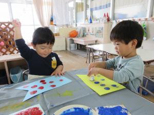 ２人の子どもがスタンプを楽しそうに押しています。