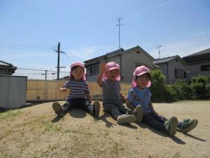 ３人の子どもが築山にのぼっています。