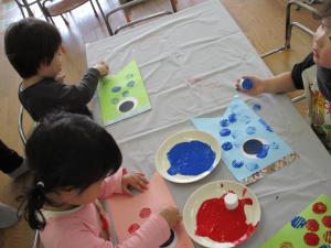 ３人の子どもがスタンプを押しています。