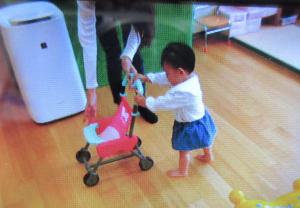 おもちゃのベビーカーを押している