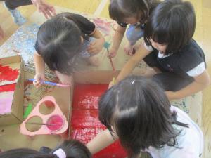 絵の具を使って段ボールを塗るところ