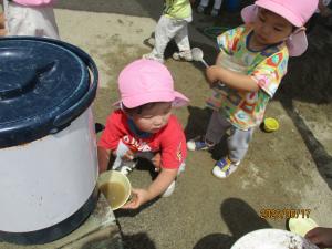 2人でおわんに水を汲んでいる