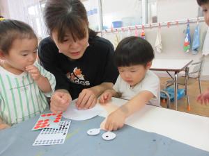 3人でかたつむりの顔にシール貼りをしている
