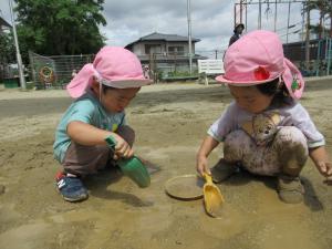 2人がスコップで泥をつんつんつついている