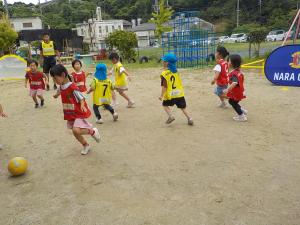 サッカーボールを追いかける5歳児