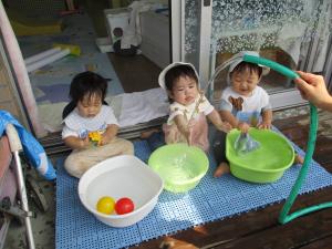 ０歳児が水遊びを楽しんでいます