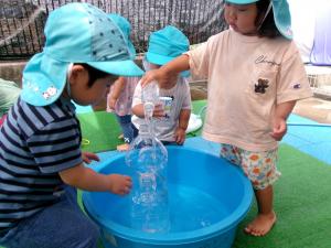 ペットボトルに真剣な表情で水を入れています