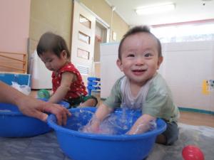 タライの水に手をつけて遊んでいる