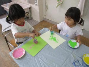 2人の子どもがタンポを使って絵を描くことを楽しんでいます。