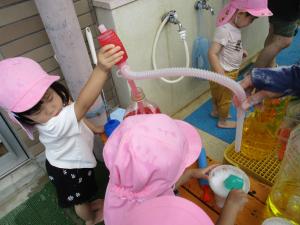 2人の子どもが色水で遊んでいます。