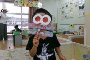 作ったとんぼの眼鏡から覗く子ども