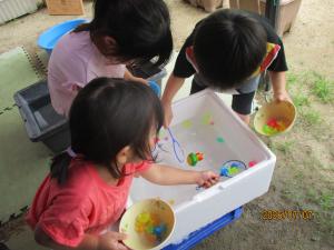 カラフルな金魚をすくう子ども
