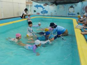 プールでわにさんをする子ども