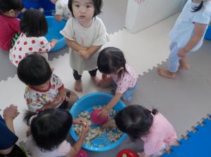 たらいに水を入れて遊ぶ子供
