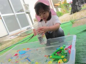 金魚すくい遊びをする子ども