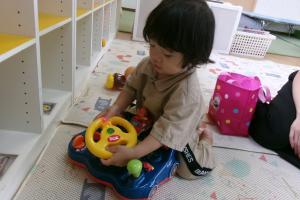 くるまのおもちゃで遊ぶ一歳児