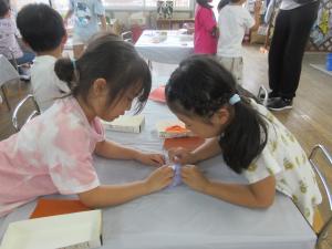 5歳児9月の製作で折り紙を教え合う様子
