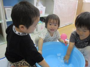 タライの氷を触っている