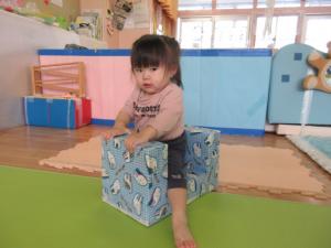 手作りの乗り物にまたがり、足で漕いで遊んでいる