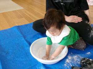 片栗粉遊びで真っ白になっている0歳児