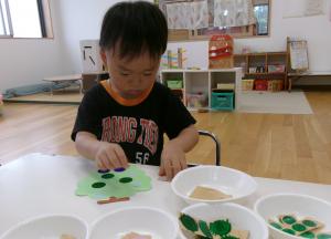 ブドウのシール貼りをしている2歳児