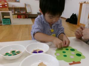 真剣な顔でシール貼りをしている2歳児